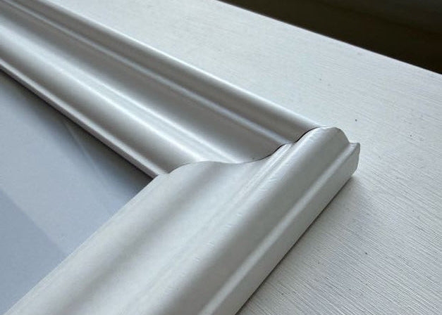 Close-up of a white window frame corner with a textured wall background